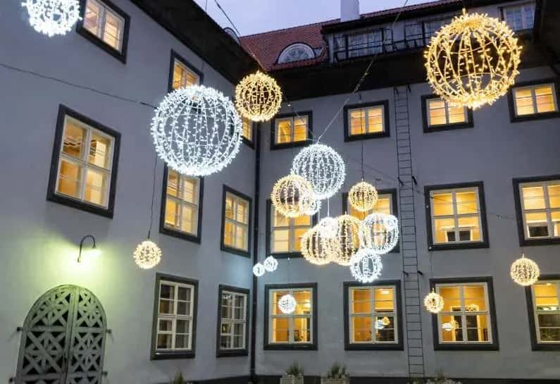 Tarihi bina avlusunda tellerden sarkan soğuk ve sıcak beyaz büyük ışık topları
