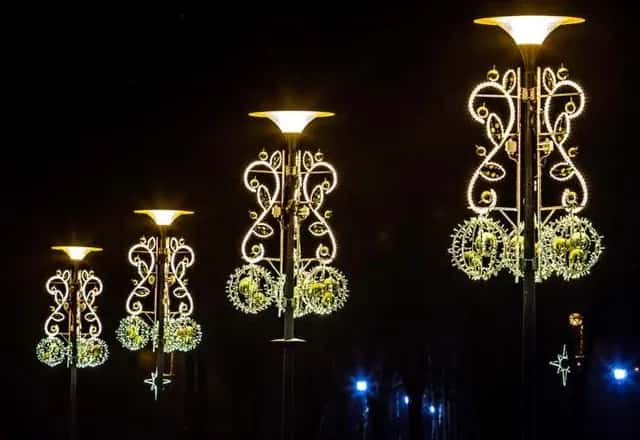 Meydanda ışıklı direk başlıkları ve yaprak dallı küre sarmalları, gece