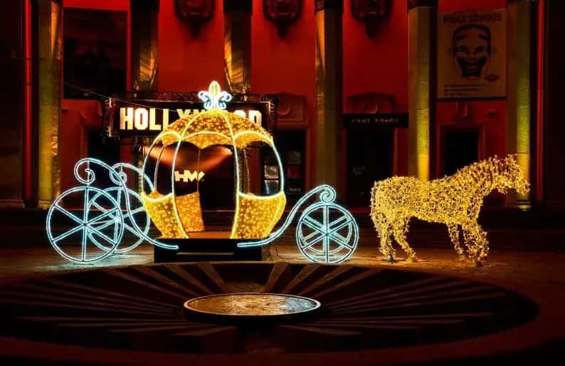 AVM girişinde altın kabak araba ve at heykeli, Hollywood temalı tabela önünde