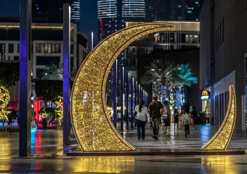 Modern cadde üzerinde altın sarısı LED hilal tak, arkada gökdelenler