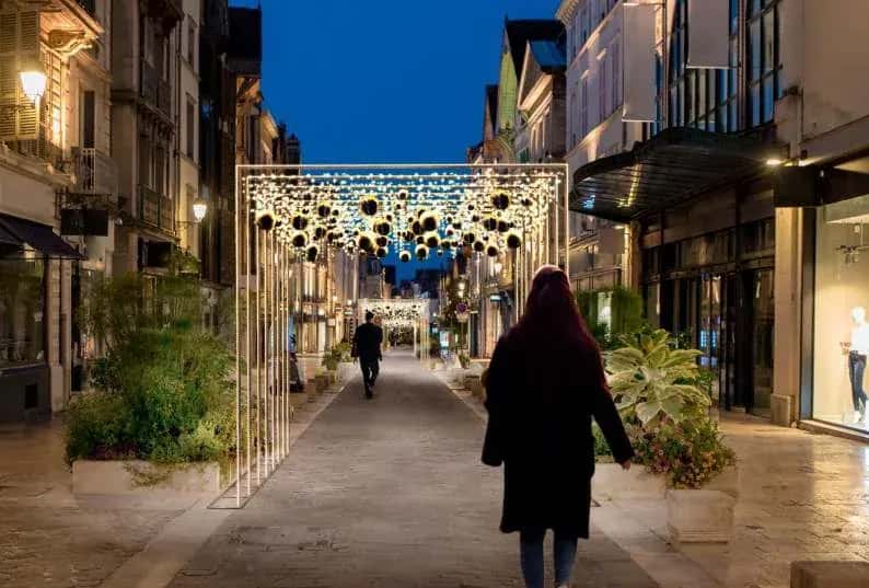 Yaya caddesinde sarkıt toplu geçit takının altından yürüyen kadın, akşam mavisi gökyüzü
