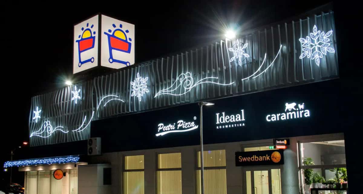 Alışveriş merkezi cephesinde beyaz kar tanesi ve dalga ışıkları, gece