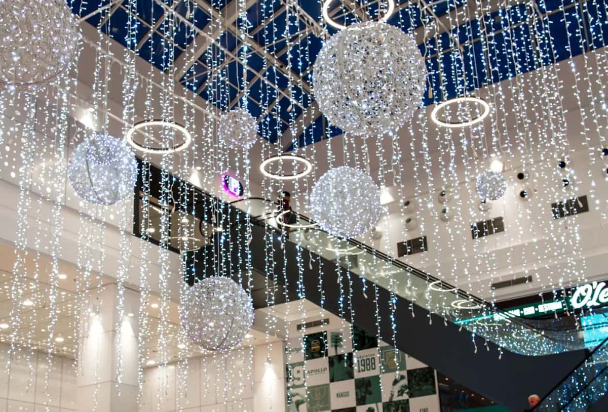 Alışveriş merkezi atriumunda tavandan asılı beyaz LED küreler, halkalar ve soğuk beyaz perde
