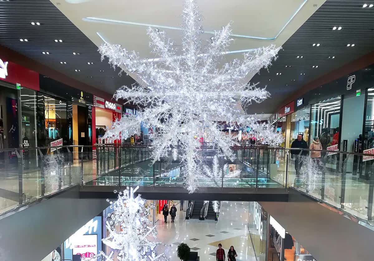 Alışveriş merkezi boşluğunda tavandan sarkan dev soğuk beyaz dallı LED kar tanesi