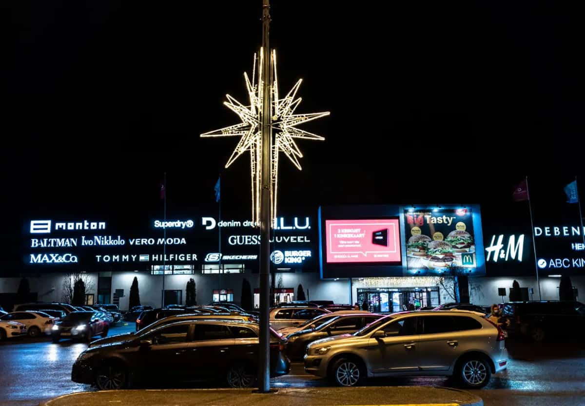 Alışveriş merkezi önünde otoparkta yüksek direğe monte altın sarısı yıldız motifi, gece