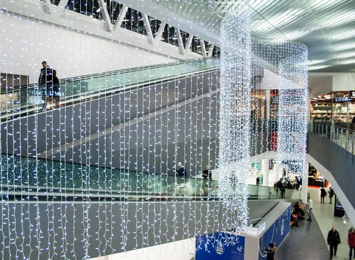 Yürüyen merdivenli alışveriş merkezinde soğuk beyaz LED perde ve silindir sütunlar