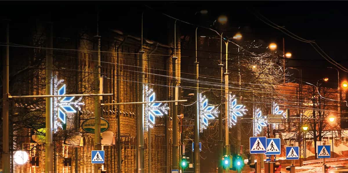 Cadde direklerine sıralı monte edilmiş mavi beyaz kar tanesi motifleri, gece