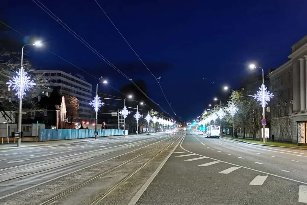 Tramvay hatlı geniş caddede direklere sıralı soğuk beyaz kar tanesi motifleri, gece