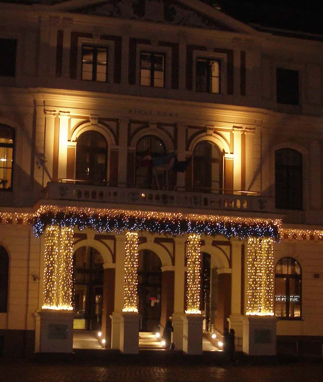 Gece tarihi binanın giriş sütunlarına sarılı sıcak beyaz LED ve mavi balkon şeridi