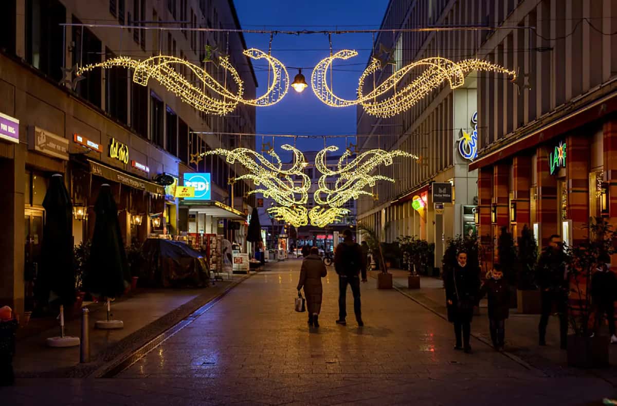 Yaya caddesi üzerinde asılı sıcak beyaz sarmal ve yaprak motifleri, gece