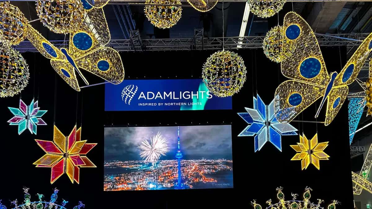 Fuar standında tavandan sarkan altın kelebekler, renkli yıldızlar ve LED toplar