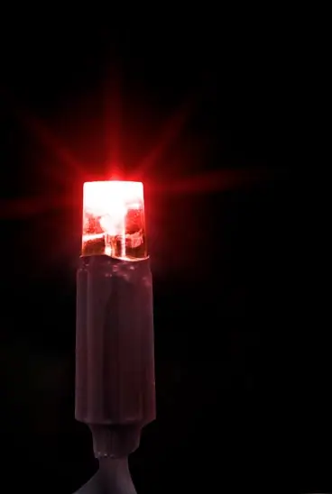 Siyah fonda koyu gövdeli, ışın saçan kırmızı LED lamba, dikey kadraj