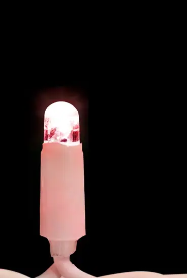 Siyah fonda pembe gövdeli, kırmızı yanan LED lamba