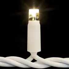 Siyah fonda beyaz kablo üzerinde yanan sıcak beyaz tek LED lamba, yakın çekim