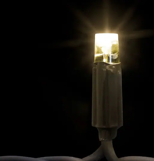 Siyah fonda gri yeşil gövdeli, ışınlar saçan sıcak beyaz tek LED lamba