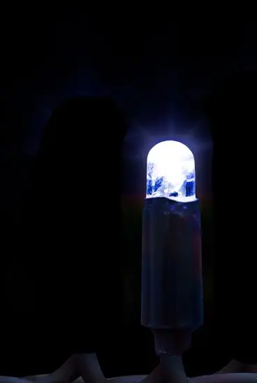 Siyah fonda karanlık gövdeli, soğuk beyaz yanan tek LED lamba, dikey kadraj