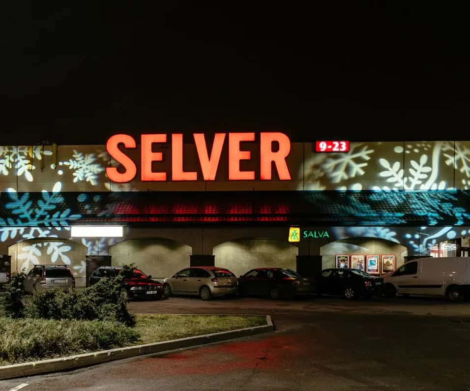 Gece market cephesine yansıtılmış beyaz ve turkuaz kar tanesi desenli ışık projeksiyonu