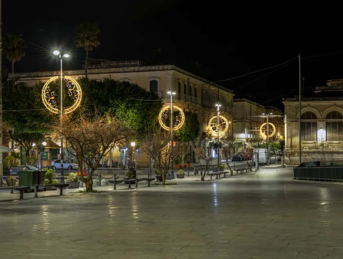 Palmiyeli meydanda lamba direklerine monte altın halka motifleri, gece