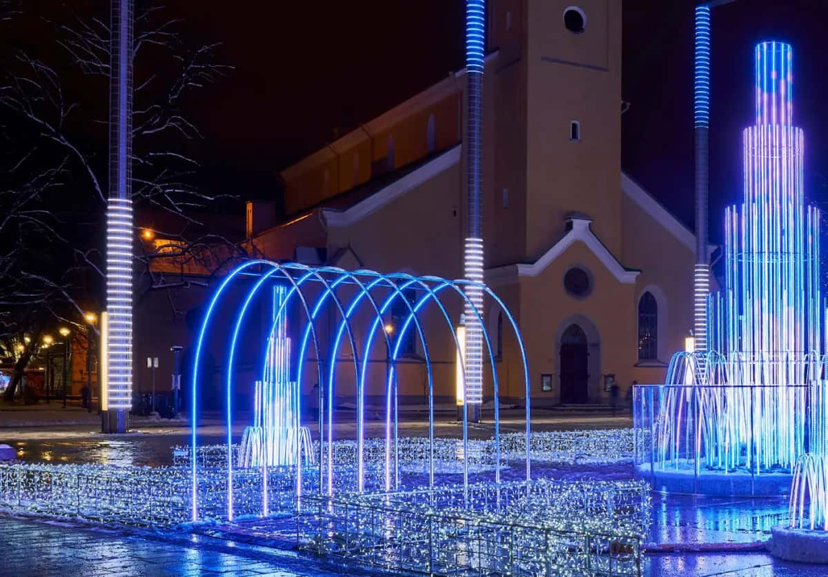 Kilisenin önündeki meydanda mavi LED kemer dizisi ve ışıklı çeşmeler, gece