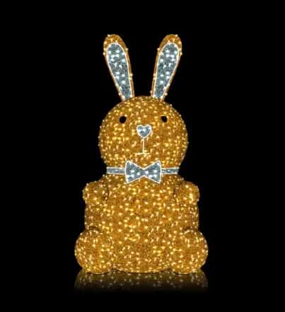 Siyah fonda gümüş kulaklı ve papyonlu, oturan altın sarısı LED tavşan figürü